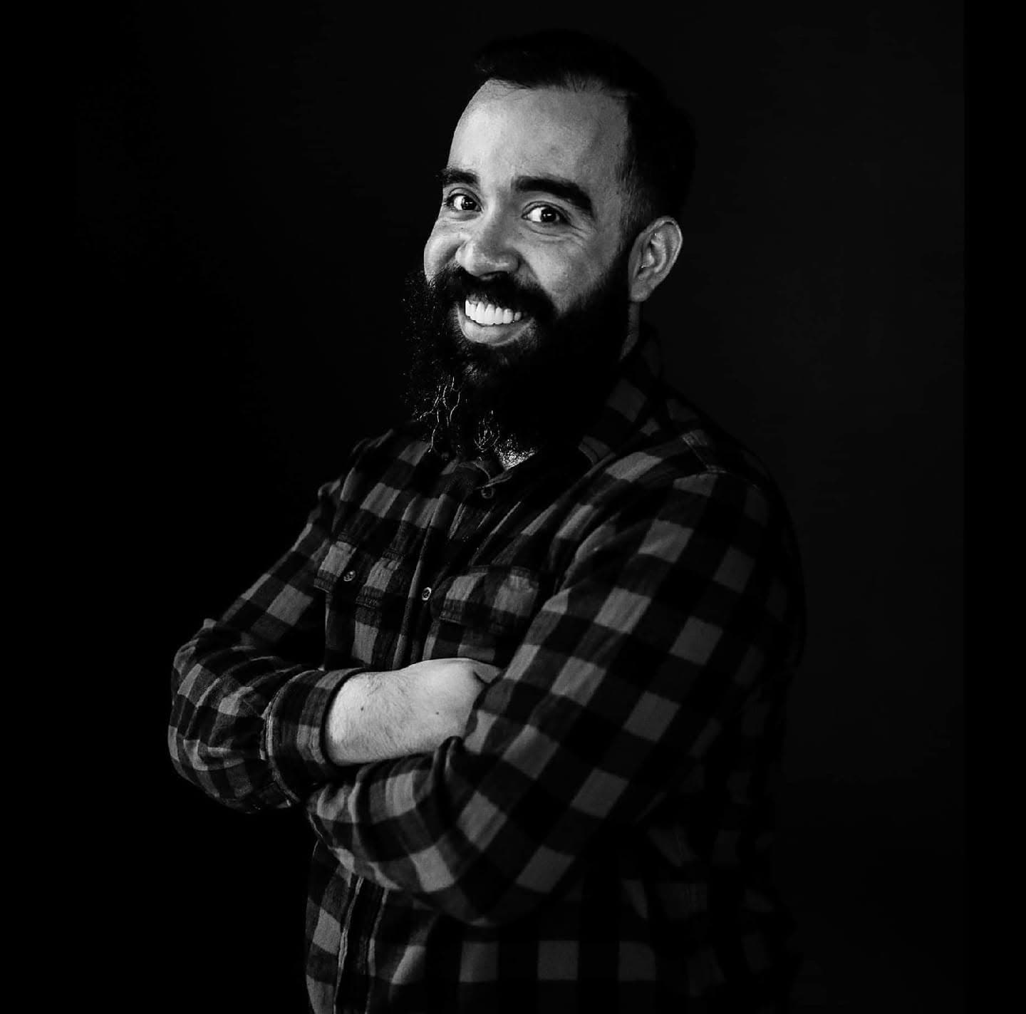 Jorge Jacome smiling in a black-and-white portrait